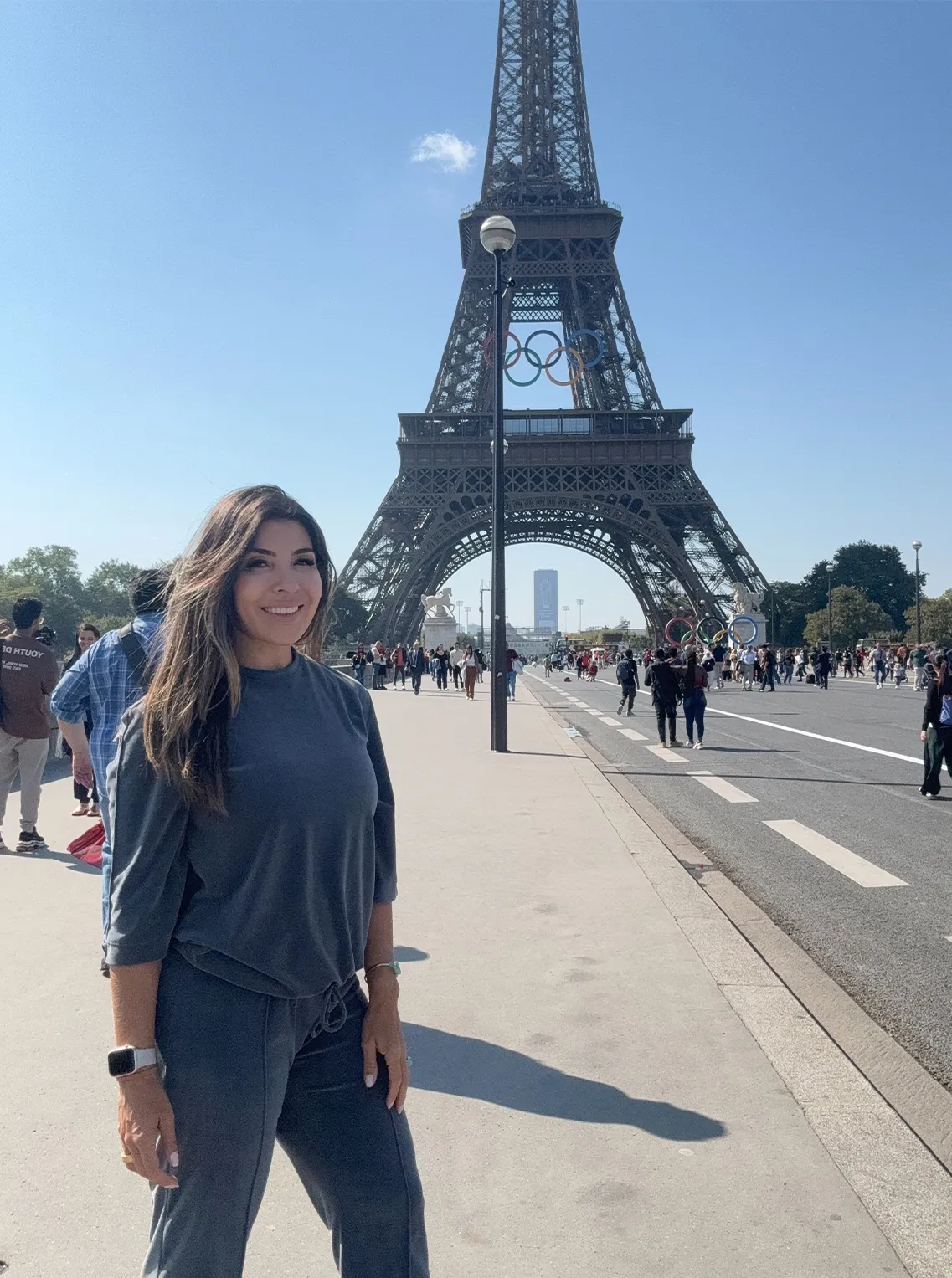 Woman in a denim outfit posing in front of the Eiffel Tower in Paris